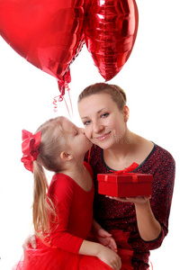 女孩亲吻母亲，用气球送礼品盒