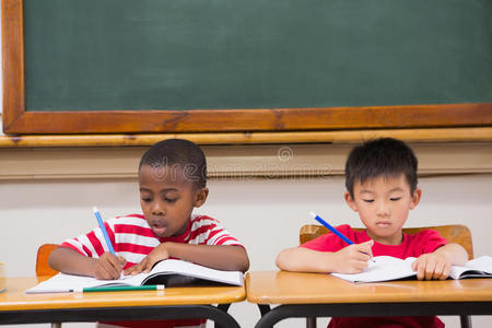 可爱的小学生在教室里写字