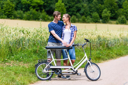 一对夫妇在乡下一起骑双人自行车