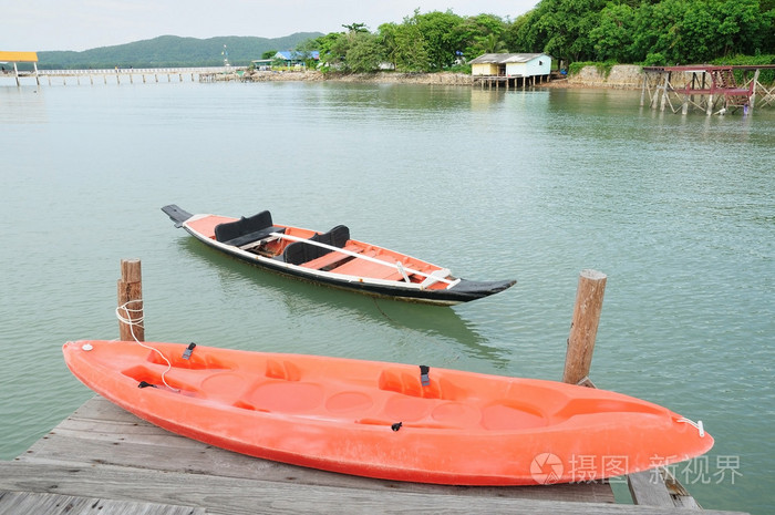 当地的木排船漂浮在海上,独木舟在木海港上