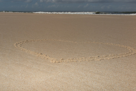 美丽的心形状绘制在沙子图片