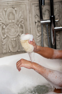 洗澡的女人用海绵清洁自己。