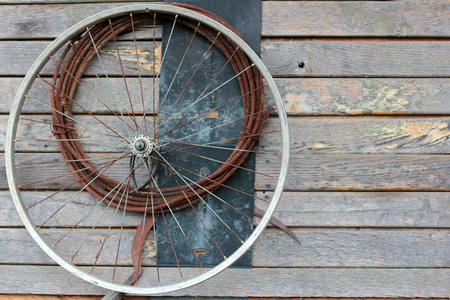 旧自行车轮和木墙上生锈的电缆图片