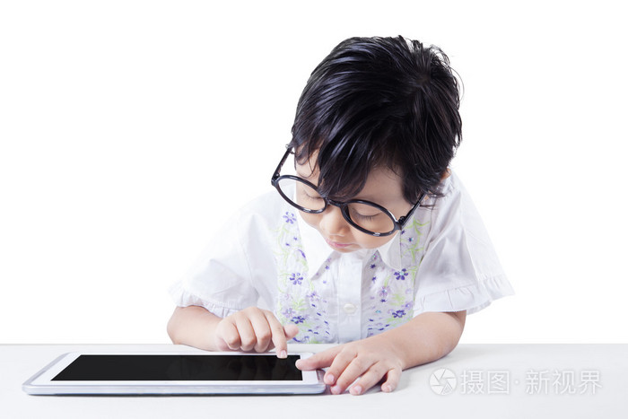 小女孩使用平板电脑在桌子上