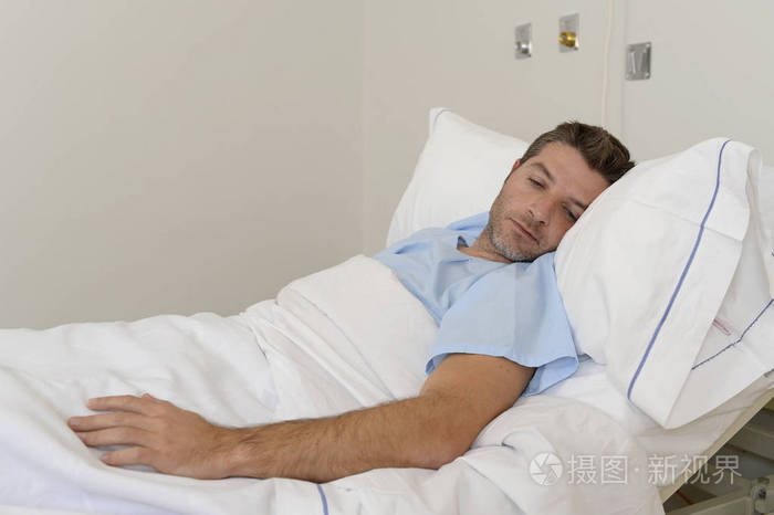 年轻有耐心的人躺在医院的床上休息累了看难过和沮丧担心