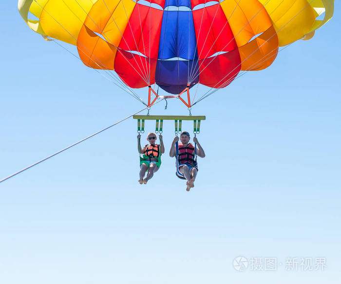 对幸福的夫妇水上滑翔伞在多米尼加夏季海滩.几下悬挂半空中降落伞.