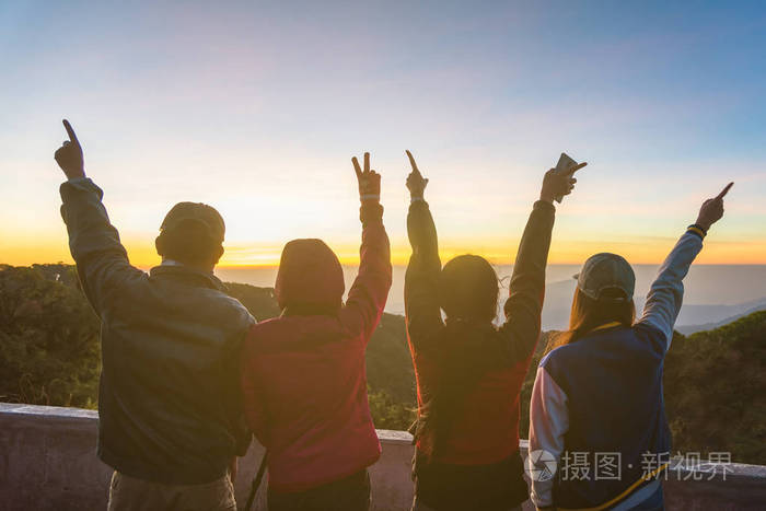 快乐的人举手与太阳背景的剪影
