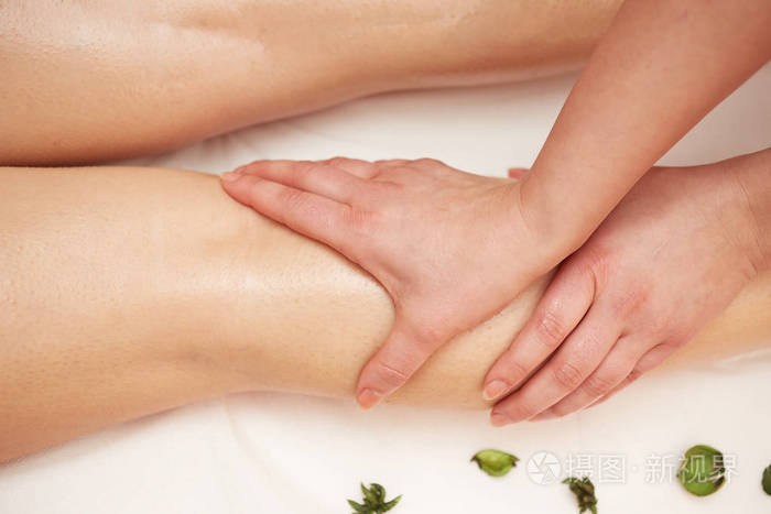 详细的手按摩人体小腿肌肉治疗师对女性腿施加压力