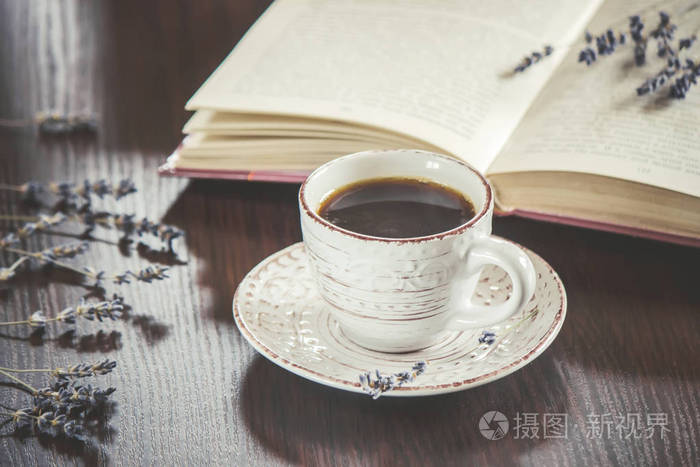 热杯咖啡和在休闲阅读一本书.选择性的焦点