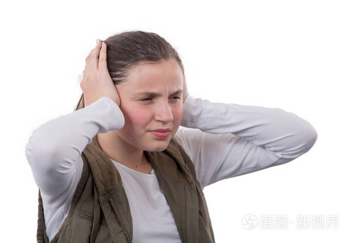 一个年轻的十几岁的女孩双手捂住耳朵不听噪音