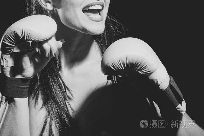 性感的女孩拳击手在黑色背景上的锻炼