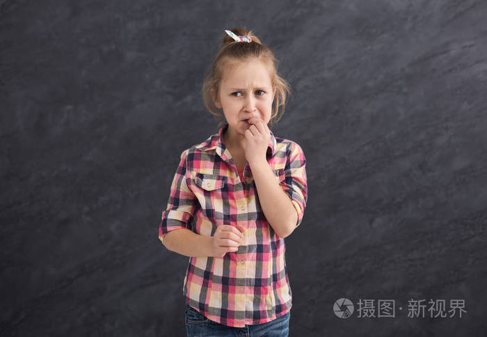 灰色背景下的小女孩愁眉苦脸