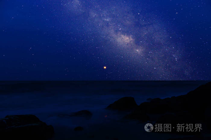 蓝色的小血月在漆黑的夜晚,在海中有星星尘埃和银河系