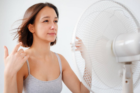 在电风扇通风器前提神的女人图片