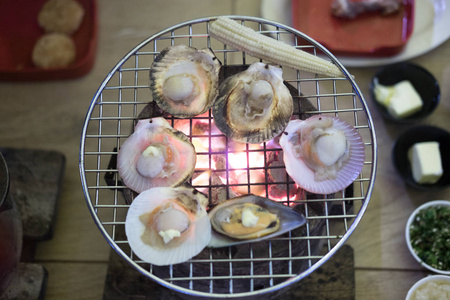 在自助餐烧烤架上用黄油烤扇贝图片