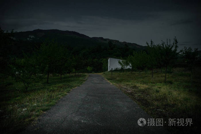 夜晚用月亮或老式乡村住宅在森林中建造的山夜景观,夜晚用云彩和星星.