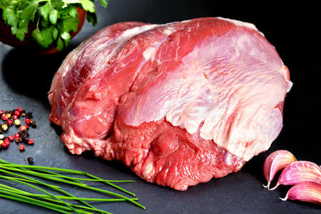 新鲜的生肉。整块红肉准备在烤架或烧烤上烹饪。背景