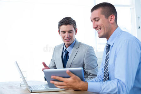 商人与笔记本电脑和平板电脑一起工作