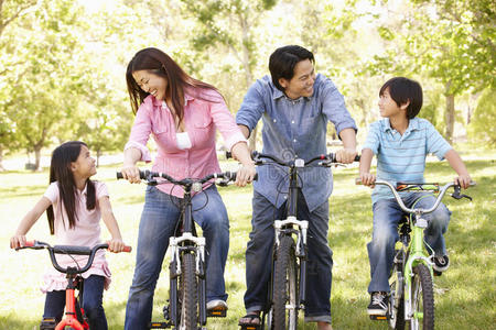 亚洲家庭在公园骑自行车