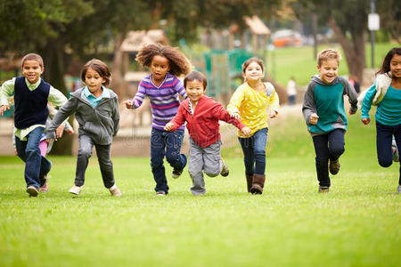 一群小孩子在公园里向摄像机跑去
