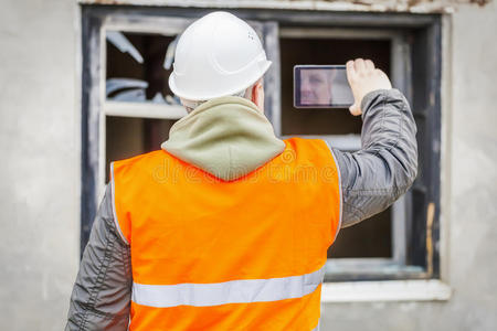 建筑检查员在建筑物附近用手机拍摄