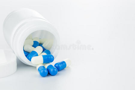 蓝色和白色药丸，白色背景上的药丸瓶