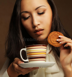 亚洲女人和咖啡和饼干。