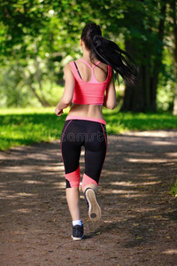 美丽的女人跑步在城市公园跑步