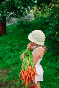 女孩用一串胡萝卜啃胡萝卜