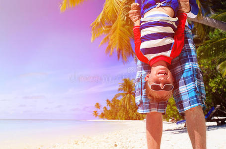 爸爸和小儿子在夏天的海滩上玩耍