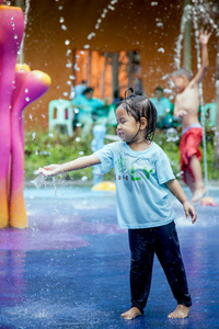 小女孩在公园喷泉玩水玩得很开心
