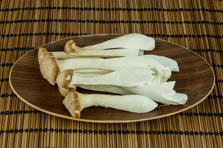 大牡蛎蘑菇杏鲍菇装饰在盘子上的木制背景。