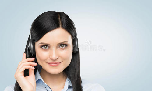 带耳机的微笑黑发支持电话接线员的正面视图。