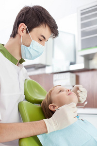 有吸引力的年轻牙医正在治疗小孩子