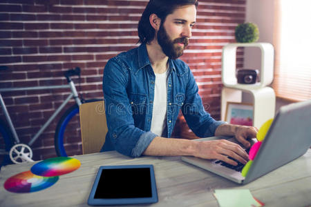 创意商人使用笔记本电脑通过图形平板电脑在桌子上