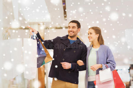 商场里拎着购物袋的幸福小夫妻