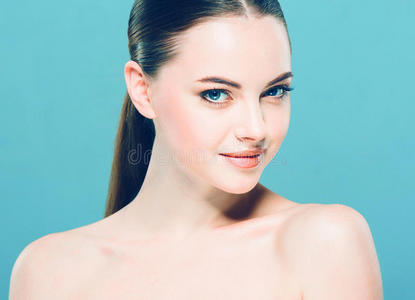 美女面部肖像。 美丽的水疗模特女孩，完美的新鲜清洁皮肤。 蓝色背景。