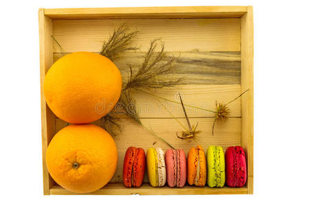 彩色马卡龙和橙色在白色背景的木箱。