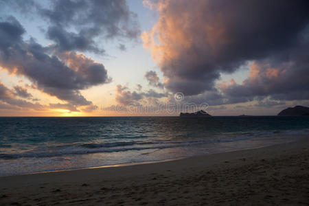 清晨日出在怀马纳洛海滩上的海洋上冲破云层