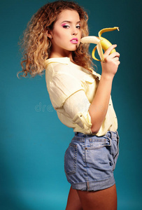 美丽的年轻女孩，金色的头发和明亮的化妆香蕉