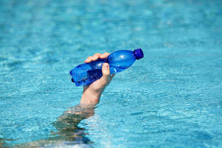 手拿塑料水瓶放在水面上