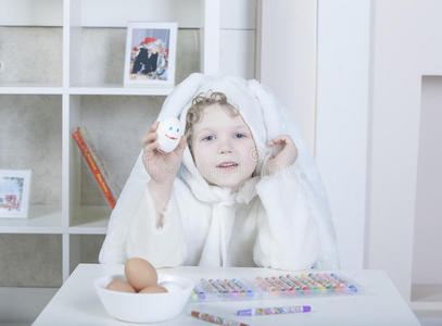 穿着复活节兔子套装的男孩画鸡蛋