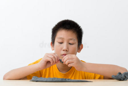 亚洲男孩在家玩粘土。
