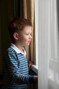 男孩站在窗户附近
