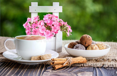 一杯咖啡，鲜花和糖果，在木制的塔布上