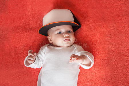 戴运动帽的婴儿展示了她的舌头
