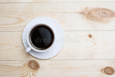 把白色咖啡杯放在木桌上