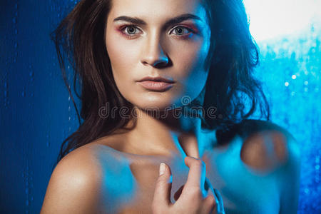 蓝色背景上美丽女性模特的美丽肖像。