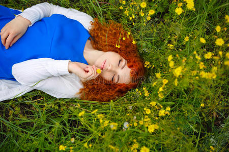 女孩躺在花丛中的草地上