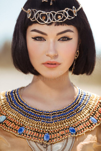 美丽的女人，时尚的化妆和发型，如埃及女王克利奥帕特拉户外对抗沙漠